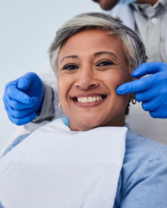 Woman with gray hair smiling in dental chair