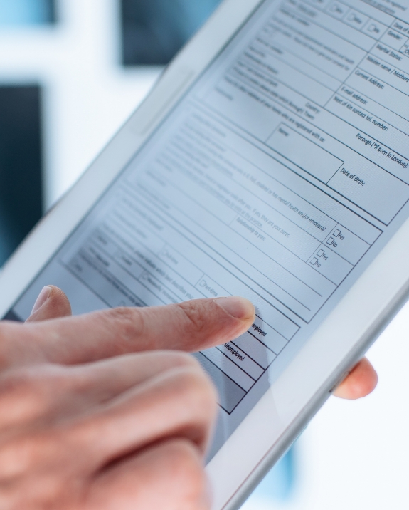 Person filling out a form on a tablet