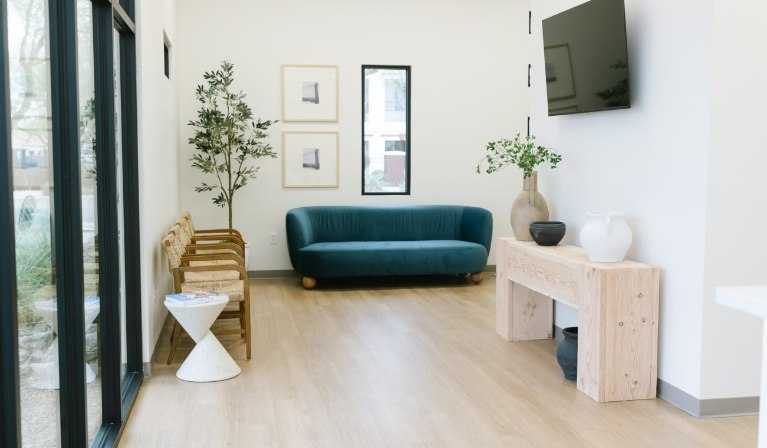 Blue couch and row of wooden chairs in reception area