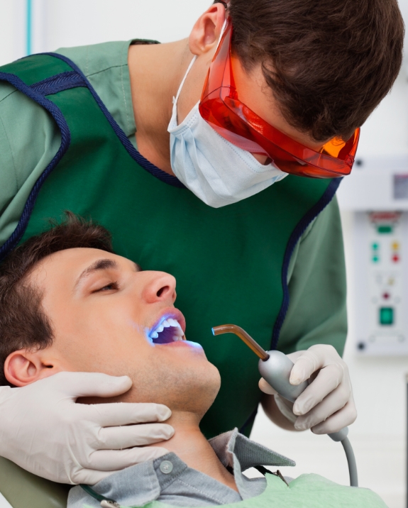 Dentist applying dental sealants to a patients teeth