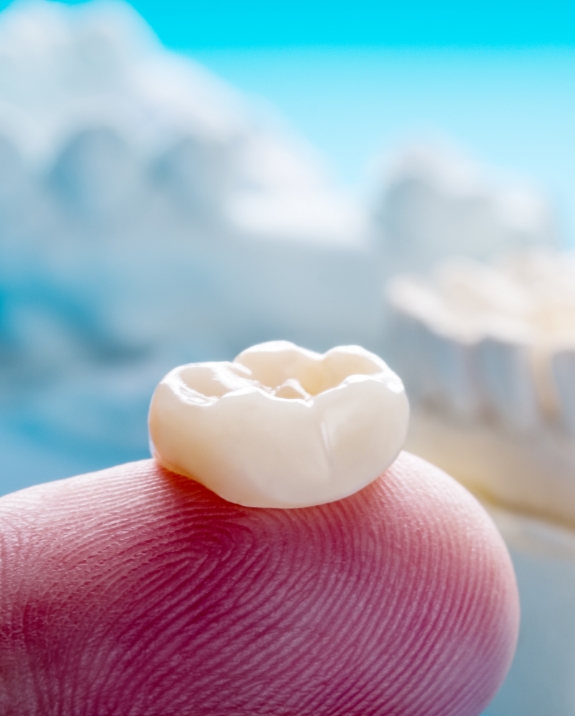 Dental crown resting on a finger