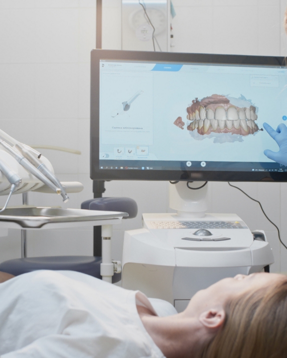 Dentist showing a patient a screen with digital model of teeth