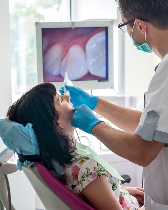 Dentist showing a patient close up photos of their teeth on screen